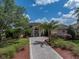 Elegant home featuring a circular driveway, well-manicured landscaping, and stately architectural details at 13538 Thoroughbred Dr, Dade City, FL 33525