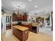 Open-concept kitchen featuring dark wood cabinetry, granite countertops and an island at 13538 Thoroughbred Dr, Dade City, FL 33525