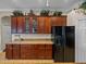 Modern kitchen featuring dark wood cabinetry, granite countertops and black appliances at 13538 Thoroughbred Dr, Dade City, FL 33525