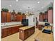Expansive kitchen featuring dark wood cabinetry, stainless steel appliances, and granite countertops at 13538 Thoroughbred Dr, Dade City, FL 33525