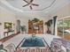 Open living space featuring a carpeted floor, tray ceiling, and access to the patio at 13538 Thoroughbred Dr, Dade City, FL 33525