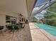 Outdoor patio with a ceiling fan, dining table and chairs next to the screened-in pool at 13538 Thoroughbred Dr, Dade City, FL 33525
