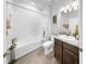 Clean bathroom with a shower-tub combo, wood vanity, and ample lighting at 13749 Hunting Creek Pl, Spring Hill, FL 34609