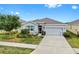Charming single-story home with a well-manicured lawn and a two car garage during the day at 13749 Hunting Creek Pl, Spring Hill, FL 34609