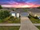 Charming single-story home with a well-manicured lawn and a two car garage at sunset at 13749 Hunting Creek Pl, Spring Hill, FL 34609