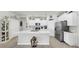 Modern kitchen with island, white cabinetry, stainless appliances, and elegant decor at 13749 Hunting Creek Pl, Spring Hill, FL 34609