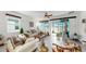 Bright living room with neutral tile flooring, comfortable seating, and a sliding glass door at 13749 Hunting Creek Pl, Spring Hill, FL 34609