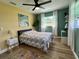 Bright bedroom featuring hardwood floors, a ceiling fan, and fresh white curtains at 14019 89Th Ave, Seminole, FL 33776