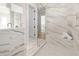 Elegant bathroom with marble-look tile, a glass-enclosed shower, and a built-in bench for relaxation at 187 145Th E Ave # 4, St Petersburg, FL 33708