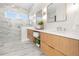 Stylish bathroom with marble-look tile, double vanity, and glass-enclosed shower for a spa-like feel at 187 145Th E Ave # 4, St Petersburg, FL 33708