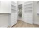 Custom closet featuring built-in shelving and drawers, complemented by wood-look floors and bathroom access at 187 145Th E Ave # 4, St Petersburg, FL 33708