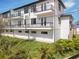 Modern exterior elevation showcases private balconies, white siding, dark window trim, and lush landscaping at 187 145Th E Ave # 4, St Petersburg, FL 33708