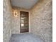 Stylish front entryway with a modern door, stone walls, and block paved floor at 187 145Th E Ave # 4, St Petersburg, FL 33708