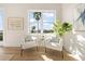 Cozy sitting area with chairs, a large window, and a serene view of palm trees at 187 145Th E Ave # 4, St Petersburg, FL 33708