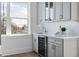 Convenient wet bar area featuring a wine fridge, sink, and stylish cabinets at 187 145Th E Ave # 4, St Petersburg, FL 33708