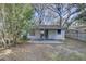An exterior view of the home's backyard including a covered patio and mature trees at 2009 E Eskimo Ave, Tampa, FL 33604