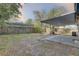 View of the spacious backyard with a covered patio, greenery, and a wooden fence at 2009 E Eskimo Ave, Tampa, FL 33604