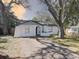 Charming home with a blue door, mature trees, and a well-maintained lawn at 2009 E Eskimo Ave, Tampa, FL 33604