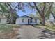 Cozy home with mature trees, blue door, and well-maintained front yard at 2009 E Eskimo Ave, Tampa, FL 33604