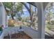 Cozy porch with seating, a small table, and views of the lush front yard at 2009 E Eskimo Ave, Tampa, FL 33604
