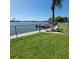 Scenic waterfront backyard with lush green grass, chain link fence, and a boat dock at 2110 Society Dr, Holiday, FL 34691