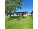 Spacious backyard with lush lawn, partial shade, and solar panels on the home's roof at 2110 Society Dr, Holiday, FL 34691