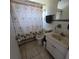 Bathroom with a palm tree shower curtain, a tiled floor, and a white vanity at 2110 Society Dr, Holiday, FL 34691