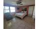 Comfortable bedroom featuring a soft recliner and a floral-patterned bedspread near a window at 2110 Society Dr, Holiday, FL 34691