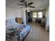Bright bedroom with a ceiling fan, floral bedspread, and a closet with curtain doors at 2110 Society Dr, Holiday, FL 34691