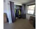 Open closet with clothing hanging from a rod, framed with violet curtain doors at 2110 Society Dr, Holiday, FL 34691