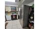 Kitchen with stainless steel refrigerator, white appliances, and tile flooring at 2110 Society Dr, Holiday, FL 34691