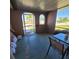 Enclosed patio with an arch-window, tile flooring, and views of a well-manicured lawn and tropical palm trees at 2110 Society Dr, Holiday, FL 34691
