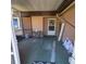 Enclosed porch area with a small table and chair, and a decorative front door with a wreath at 2110 Society Dr, Holiday, FL 34691