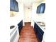 Galley kitchen with blue cabinets, stainless steel sink, and ample counter space at 2302 Maki Rd # 24, Plant City, FL 33563