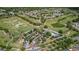 Expansive golf course aerial showcasing ponds, trees, clubhouse, parking and surrounding neighborhood at 23734 Coral Ridge Ln, Land O Lakes, FL 34639