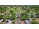 An aerial view of the clubhouse surrounded by a lush green golf course and a pond with palm trees in the center at 23734 Coral Ridge Ln, Land O Lakes, FL 34639