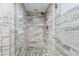 Modern walk-in shower featuring stylish tiled walls, rainfall shower head, and decorative pebble floor at 2618 Cove Cay Dr # 801, Clearwater, FL 33760