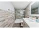 A renovated bathroom features stone-look walls, glass shower doors, and modern fixtures at 2618 Cove Cay Dr # 801, Clearwater, FL 33760