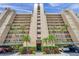 A low angle of a condo building with balconies, palm trees, and covered parking at 2618 Cove Cay Dr # 801, Clearwater, FL 33760