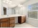 Bathroom featuring double sinks, a vanity, large mirror, and a shower-tub combo at 26517 Castleview Way, Wesley Chapel, FL 33544