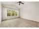 Carpeted bedroom features large window with view and a ceiling fan at 26517 Castleview Way, Wesley Chapel, FL 33544