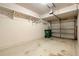 This is a single-car garage with storage shelving, a trash can, and a roll-up garage door at 26517 Castleview Way, Wesley Chapel, FL 33544