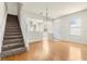 Cozy living space featuring hardwood floors, a staircase, and an open layout to the kitchen at 26517 Castleview Way, Wesley Chapel, FL 33544