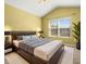 Spacious main bedroom with vaulted ceiling, large window, and a king bed set on a shag rug at 26517 Castleview Way, Wesley Chapel, FL 33544