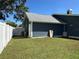 A well maintained exterior with a gray roof, blue siding, and a lush green lawn at 3000 Tangerine Ter, Palm Harbor, FL 34684