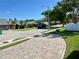 Neighborhood street view with mature trees, well-maintained lawns and brick paver driveways at 3000 Tangerine Ter, Palm Harbor, FL 34684