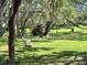 A backyard playground invites fun and adventure with a slide, wooden play structure, and lots of green space for activities at 3000 Tangerine Ter, Palm Harbor, FL 34684