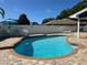 Inviting swimming pool with brick surround, poolside seating, and privacy fence at 3000 Tangerine Ter, Palm Harbor, FL 34684