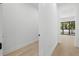 Bright hallway with light wood floors and white trim leads to a bright living area with large windows at 3020 W Helen Ave, Tampa, FL 33611