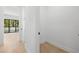 Bright hallway with white trim and light wood floors, leading to a bright living area with large windows at 3020 W Helen Ave, Tampa, FL 33611
